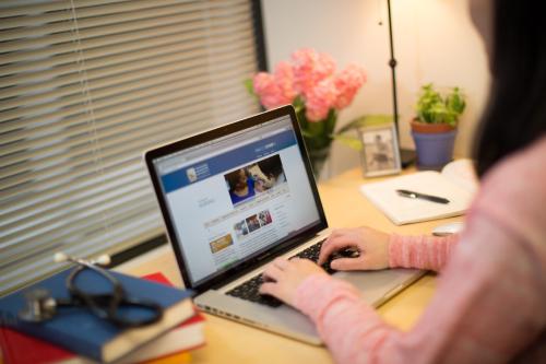 A girl working remotely at a laptop by a window